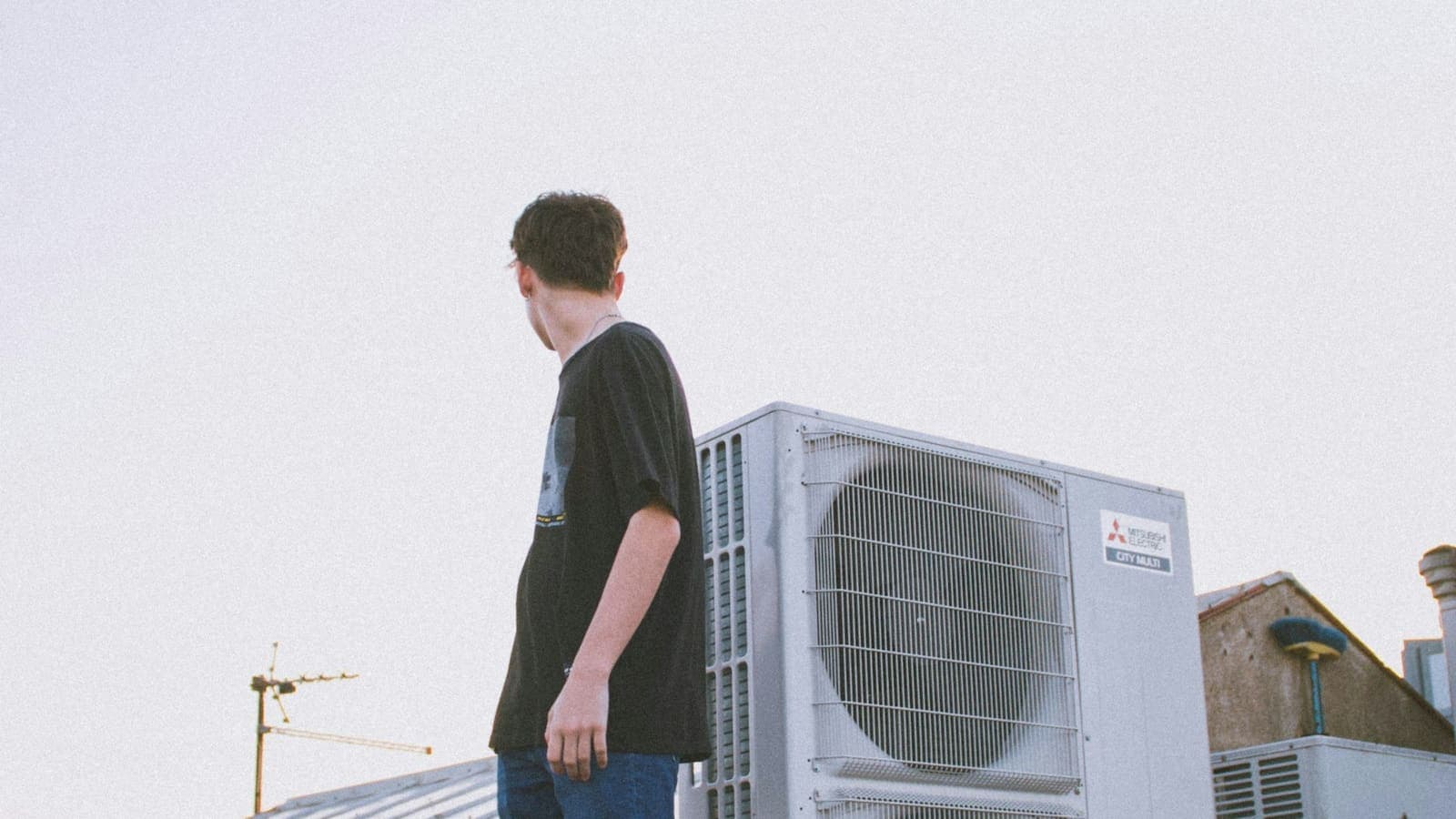 HVAC technician servicing a rooftop unit on a commercial building
