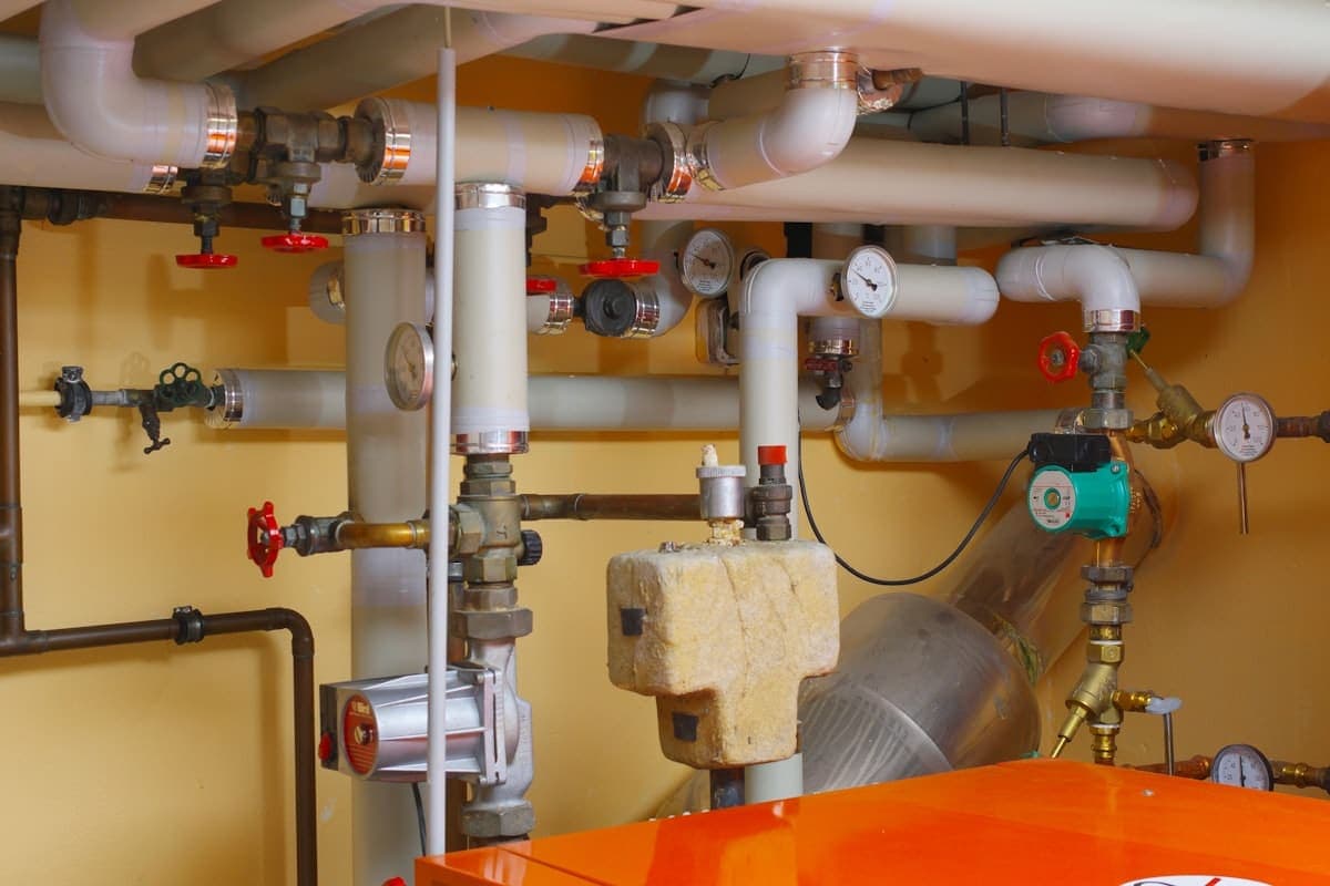 Plumber checking Houseler on a phone in a residential basement