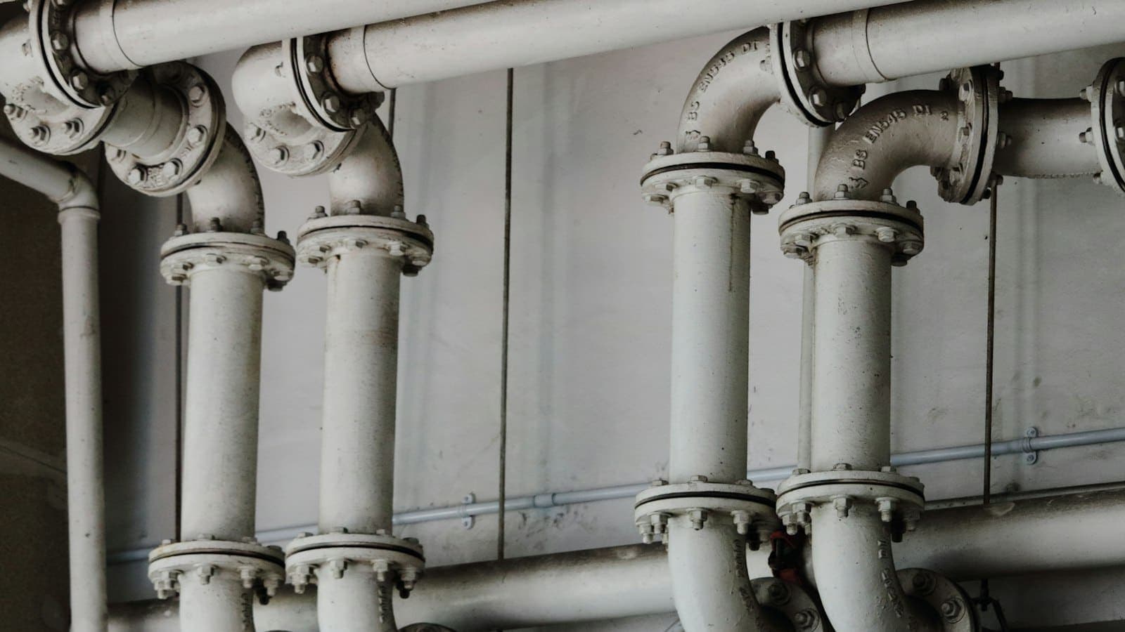 Solo plumber working under a kitchen sink on a residential service call
